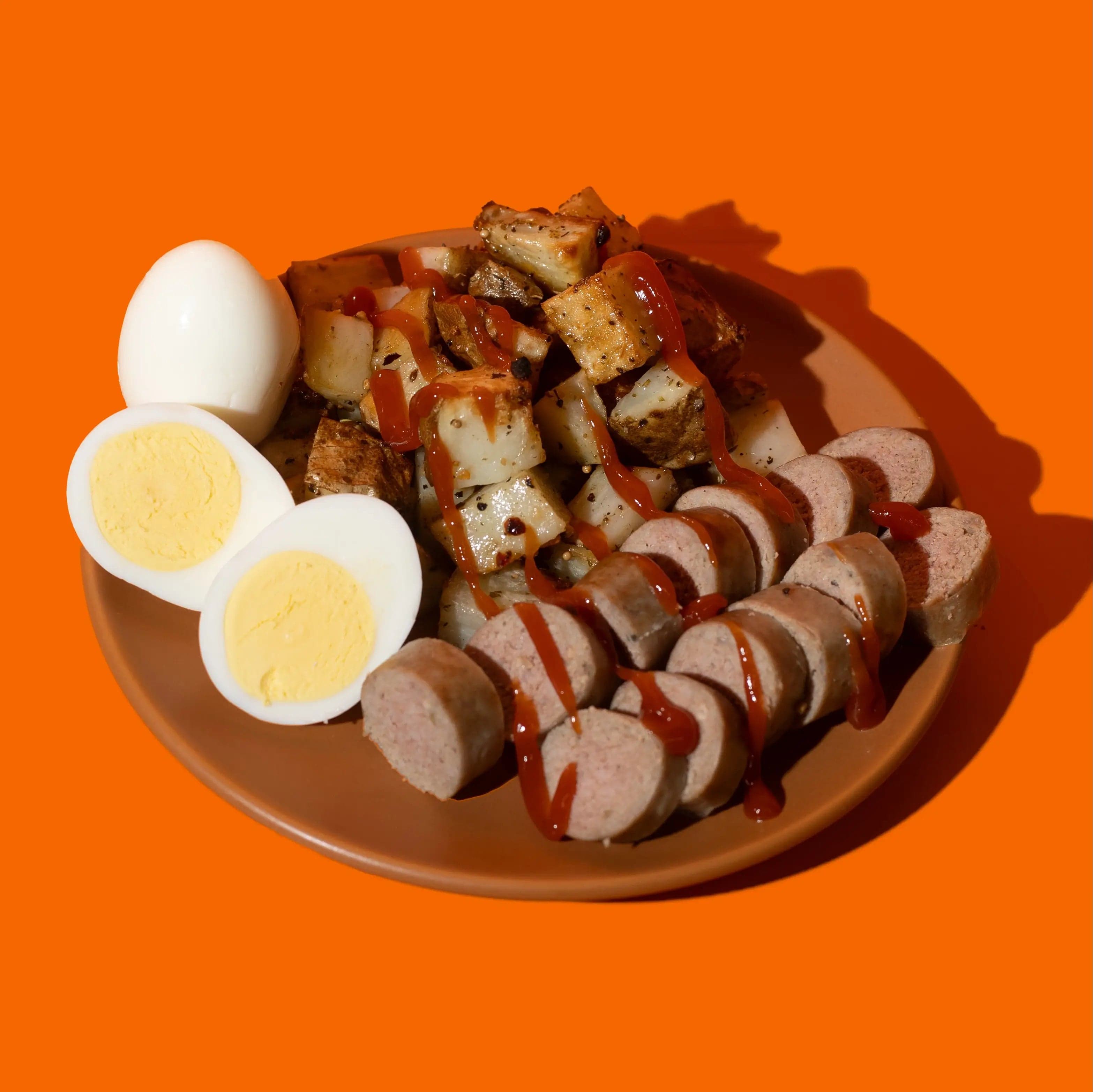 Petit-déjeuner équilibré prêt-à-manger avec œufs et saucisses, macros nutritionnelles mesurées par Big Mig pour un départ sain dans votre journée.