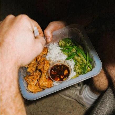 Photo aérienne d'un plat sur mesure prêt-à-manger Big Mig avec cup de sauce, poulet, riz et légumes - Livraison partout au Québec