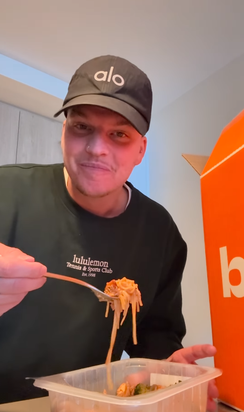 Influenceur dégustant un repas prêt à manger BigMig et montrant son appréciation du produit.