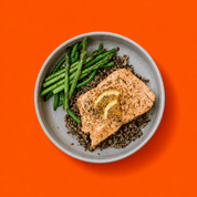 Saumon au citron et fines herbes avec quinoa, asperges et légumes verts, repas prêt-à-manger sur mesure sur fond orange