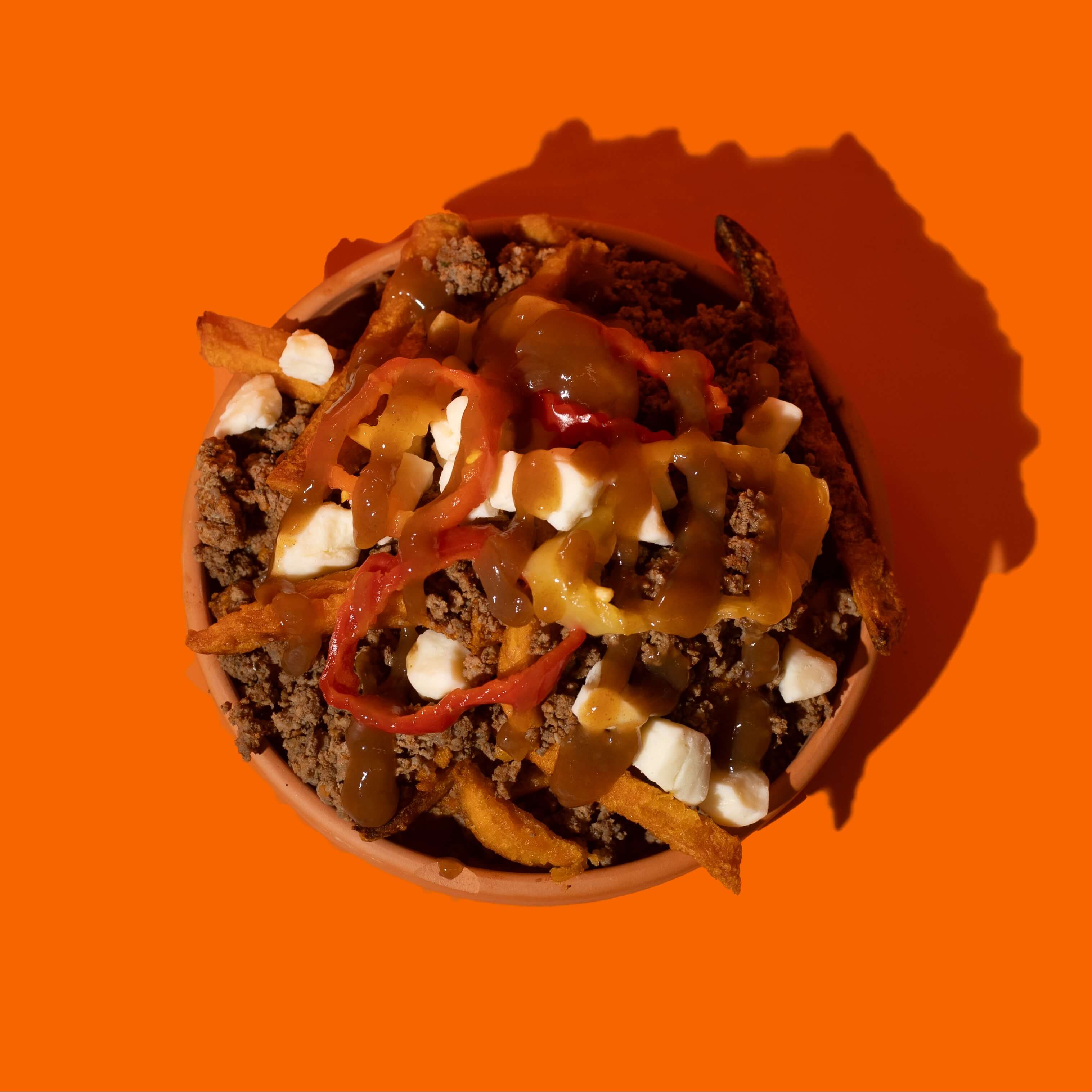 Repas prêt-à-manger Big Mig : poutine mexicaine avec frites croustillantes, fromage en grains, chili épicé et garnitures fraîches, un mélange audacieux et délicieux.