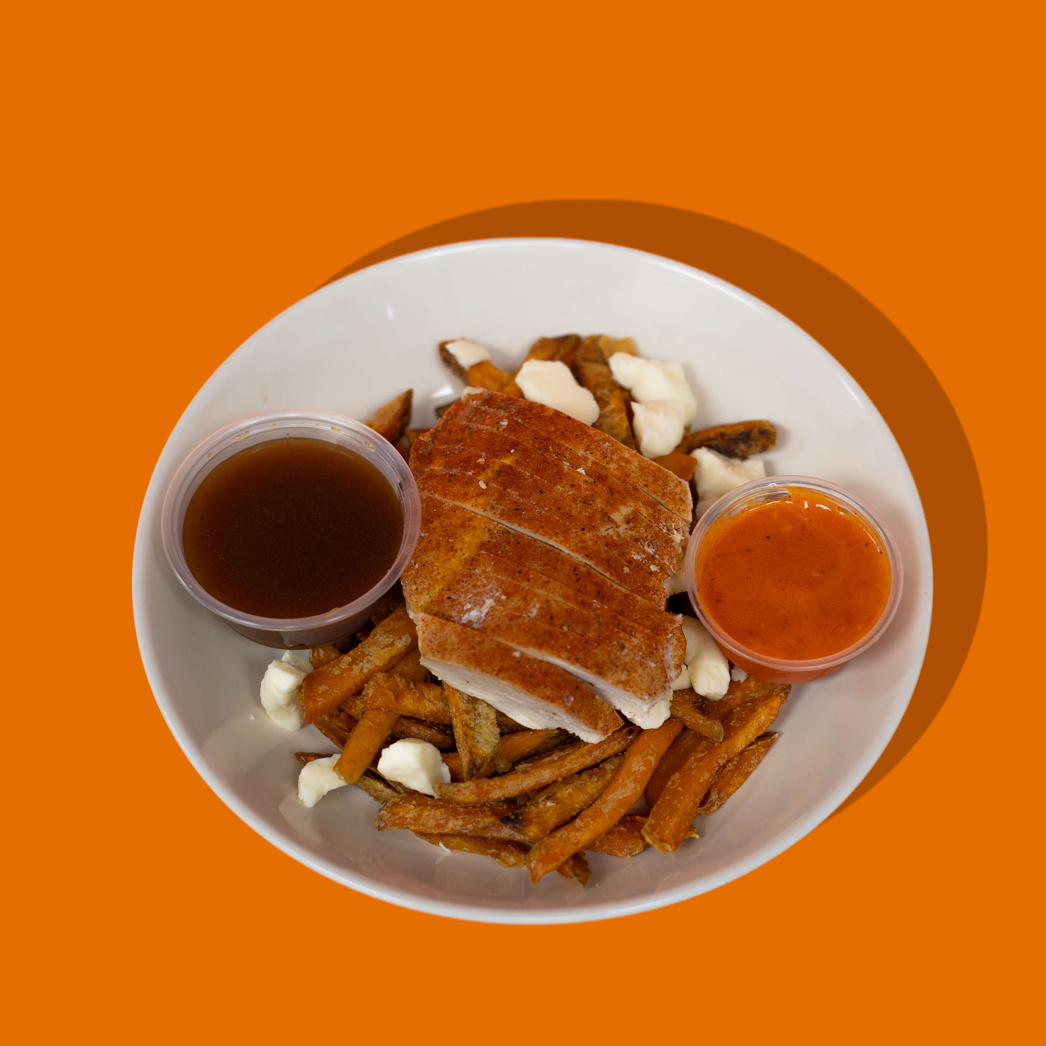 Poutine au poulet Piri Piri – repas préparé sur mesure à Montréal et environs. Poulet épicé, fromage en grains frais et sauce onctueuse, signé Big Mig.