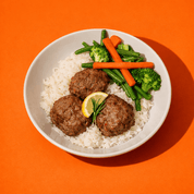 Bol de riz avec boulettes de dinde au citron et romarin, brocoli et carottes, repas prêt à manger BigMig sur fond orange.