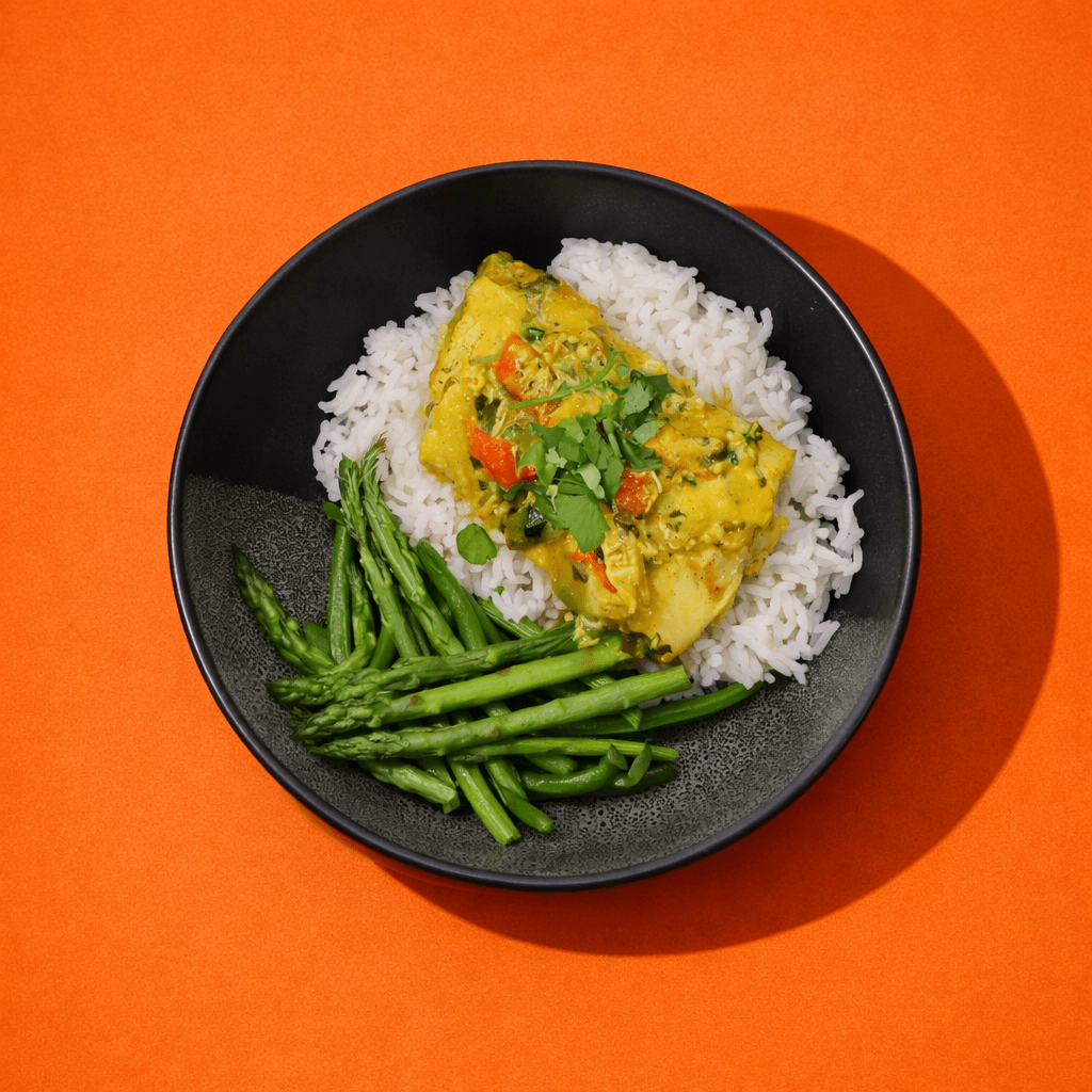 Bol de riz avec morue au cari coco et asperges, repas prêt à manger BigMig présenté sur fond orange.